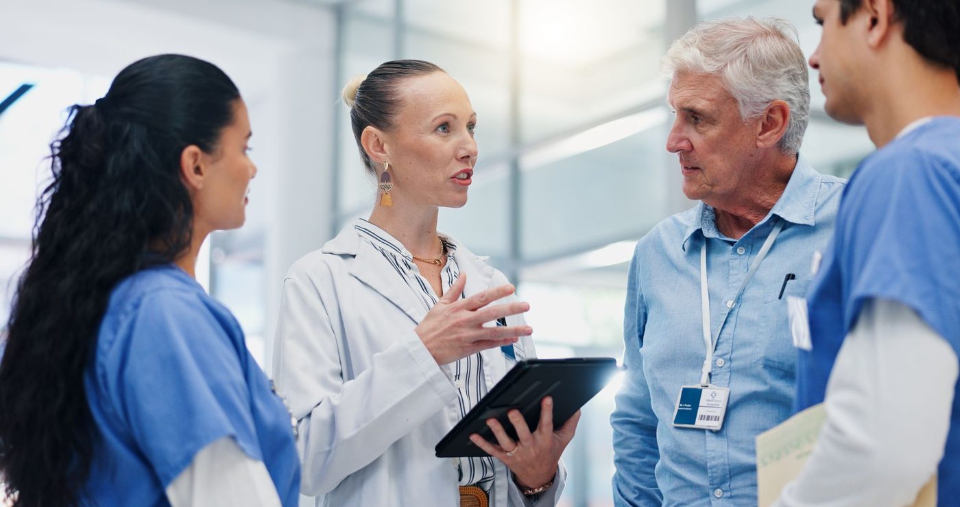 Hospital leaders reviewing coverage on a tablet
